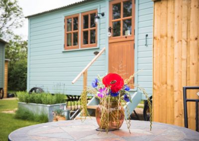 Morndyke Shepherds Huts Exterior with Table and Flower Vase